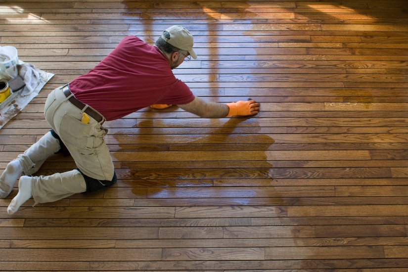 a man refinishing a wood floor